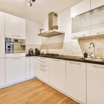 Modern kitchen remodel with white cabinets and wood flooring in Los Angeles by Trusted Contractor LA